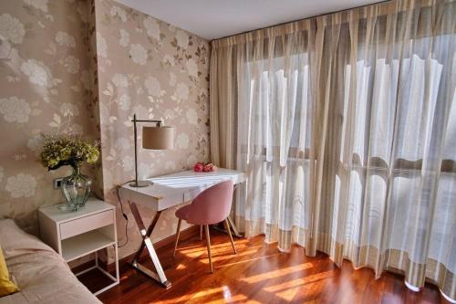 萨拉戈萨Apartamento Plaza España的一间卧室配有书桌、床和窗户。