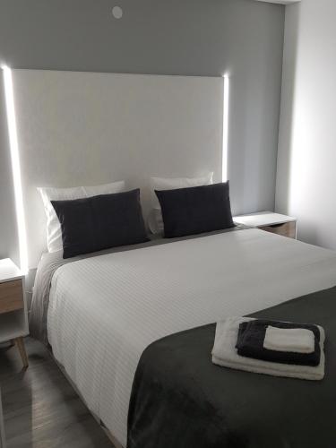代雷堡Chalet Pôr do Sol的卧室配有一张白色大床,上面有毛巾