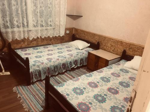 卡瓦尔纳Бунгало- Bungalow的一间卧室设有两张床、一张桌子和一个窗口