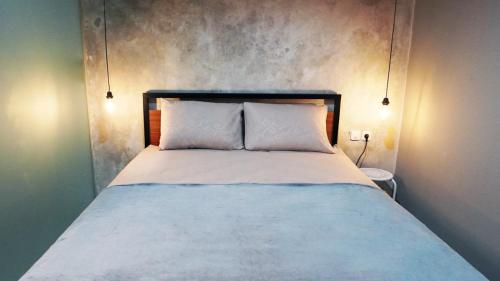 万隆Hostel 18 Pasangan Butuh Surat Nikah的一张带两个白色枕头的床