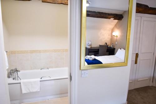 Whiston惠斯顿厅酒店的一间带镜子和浴缸的浴室