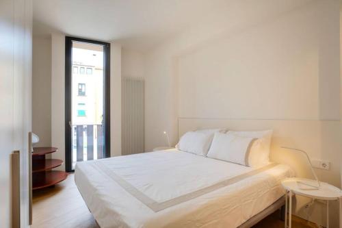 赫罗纳Flateli Rei Martí 1的白色的卧室设有一张大床和一个窗户