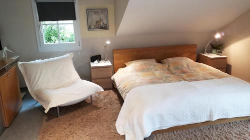 康斯坦茨Ferienwohnung CHRIS的一间卧室配有一张床和一把椅子