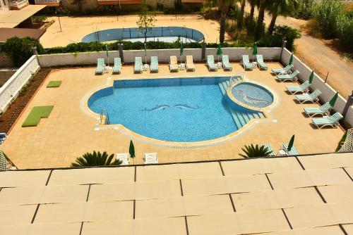 锡德Nora Suit Hotel的享有带躺椅的大型游泳池的顶部景致