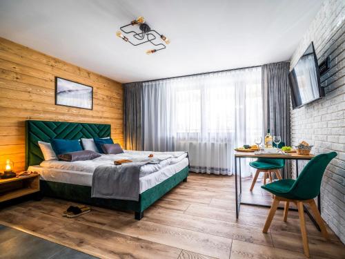 扎科帕内Apartamenty Tatrzańskie Doliny的一间卧室配有一张床、一张桌子和一张书桌