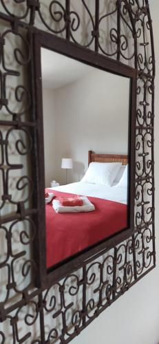 Yunquera芬卡拉斯莫雷纳斯乡村民宿的镜子反射着一张红毯的床
