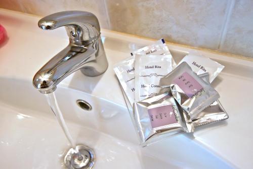 里乔内Hotel Rita的浴室水槽配有水龙头和免费肥皂
