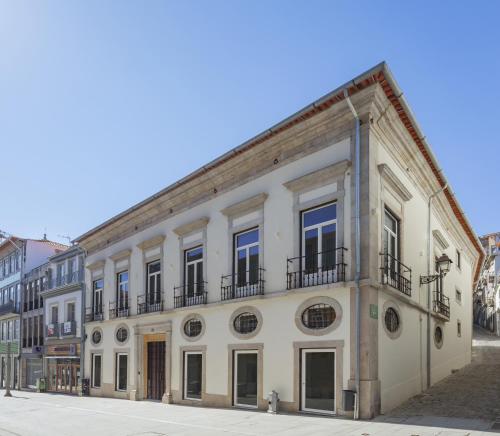 波尔图Casa da Companhia Hotel, Vignette Collection的街道上带阳台的大型白色建筑