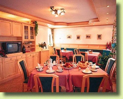 圣沃尔夫冈林奥特纳膳食公寓酒店的一间带红色桌布的餐桌的用餐室