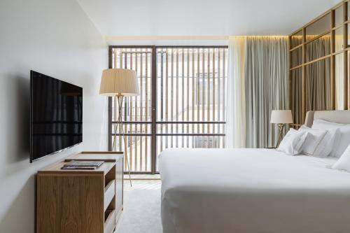 波尔图Casa da Companhia Hotel, Vignette Collection的卧室配有一张白色大床和电视。
