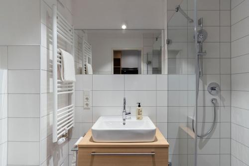 蒂宾根KONCEPT HOTEL Neue Horizonte的白色的浴室设有水槽和淋浴。