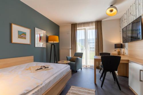 蒂宾根KONCEPT HOTEL Neue Horizonte的配有一张床和一张书桌的酒店客房