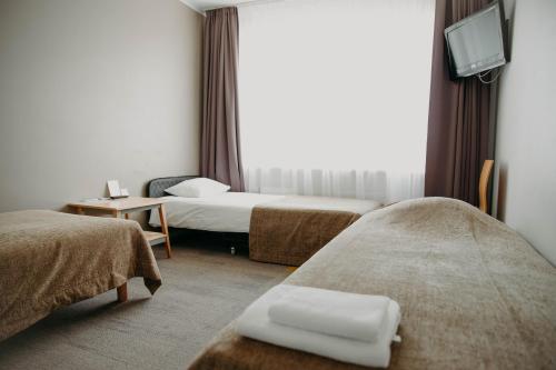 塔尔图塔尔旅馆的一间酒店客房,设有两张床和电视