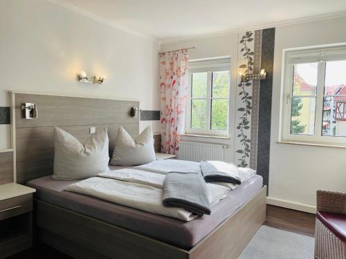 巴特索登-阿伦多夫Café Feldmann & Pension的卧室配有带白色枕头的大床