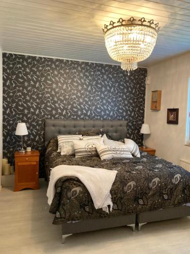 萨翁林纳Vanha omakotitalo, 3km Olavinlinnaan的一间卧室配有一张大床和一个吊灯。