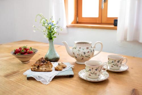 特伦塔Wild flower cottage in Trenta的一张桌子,上面放着两个茶杯和一盘食物