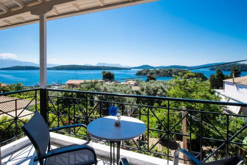 奈德里Spiros Sea View的阳台配有桌椅,享有水景。