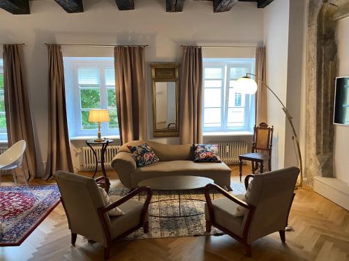 雷根斯堡金色克鲁兹酒店的客厅配有沙发和两把椅子