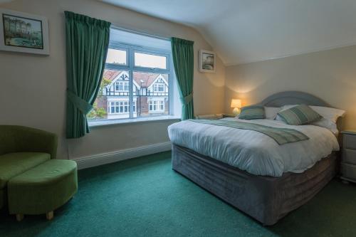 伯恩茅斯罗斯科尔特成人酒店的卧室配有床、椅子和窗户。