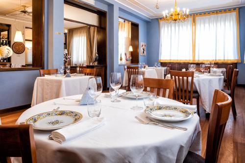 托尔托纳Albergo Cerchi的餐厅配有白色的桌椅和吊灯