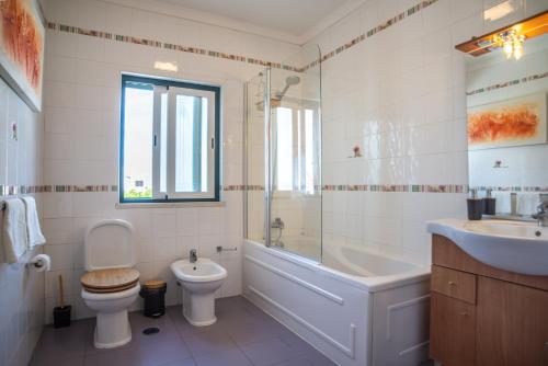 萨格里什Kichershome的浴室配有卫生间、浴缸和水槽。