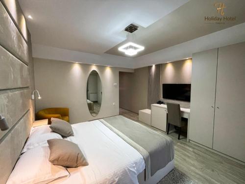 波德戈里察Hotel Holiday的一间卧室配有一张大床和一张书桌