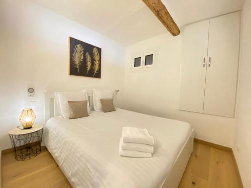芒通Vieux Château的白色的卧室配有一张白色的大床和一盏灯