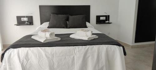 丘利利亚El Enclave的一间卧室配有一张床,上面有两条毛巾