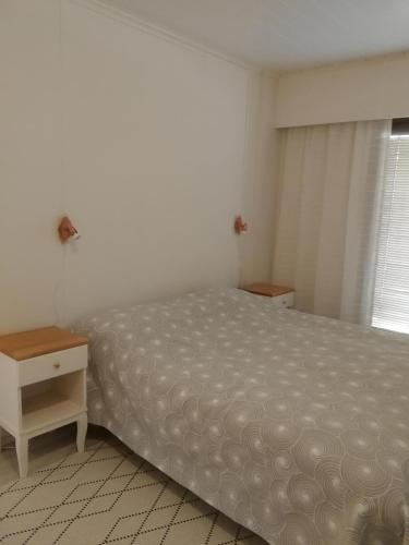 库萨莫Huoneisto Villa Kaitera的一间卧室配有一张床、一张桌子和一个窗户。
