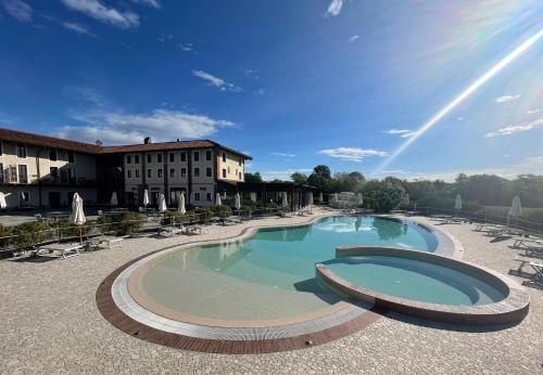 菲亚诺Relais Bella Rosina Pool & Spa的一座带椅子的大型游泳池和一座建筑