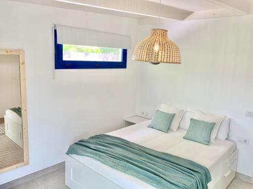 布拉内斯Villa Nature con Piscina Privada · Wifi ·AC · BBQ的白色卧室配有床和镜子