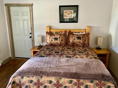 艾兰帕克Island Park Lodge的一间卧室配有一张床、两盏灯和一扇门