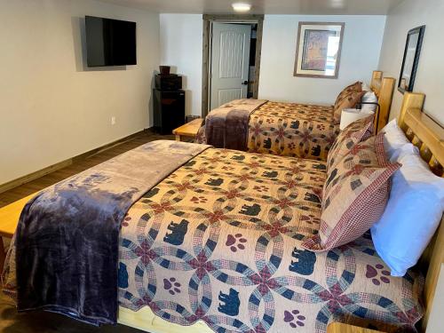 艾兰帕克Island Park Lodge的酒店客房设有两张床和电视。