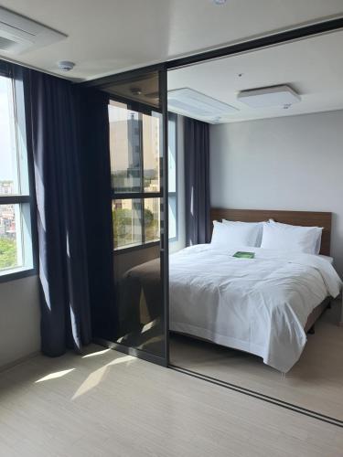 东海市Donghae Oceancity Residence Hotel的一间卧室配有一张床和一面大镜子