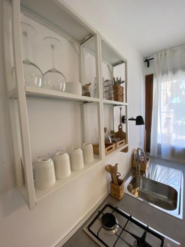 基奥贾Casa Vacanze Giorgetta Palazzina privata di due piani的厨房配有水槽和白色橱柜,提供餐具