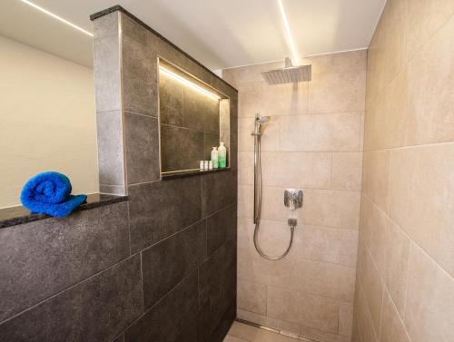 纽科琴格罗斯夫Appartement Elisabeth的带淋浴和蓝色毛巾的浴室