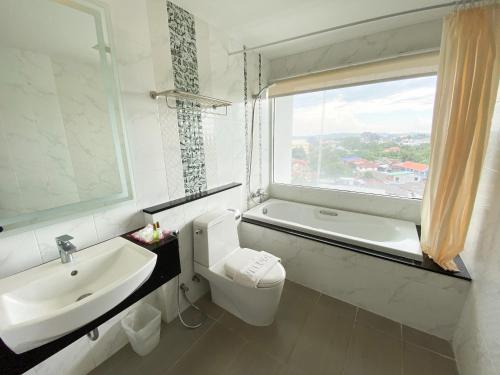 北芭堤雅Vareena palace hotel的一间带水槽和卫生间的浴室以及窗户。