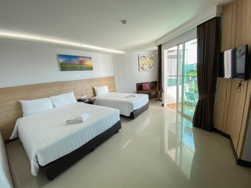 北芭堤雅Vareena palace hotel的酒店客房设有两张床和电视。