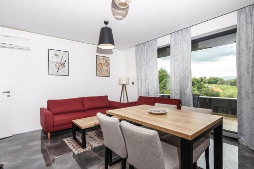 维索科Deluxe Feliciano Apartments的客厅配有红色的沙发和桌子