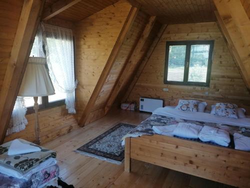 新瓦罗什Vikendica Ines的小木屋内一间卧室,配有一张床