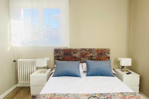 阿维莱斯Casa Vacacional Galiana的一间卧室配有一张带2个床头柜和2盏灯的床。