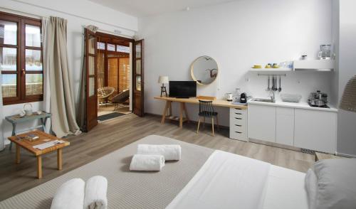 菲尼卡斯Syros Wellness Luxury Suites的客厅设有厨房和桌子