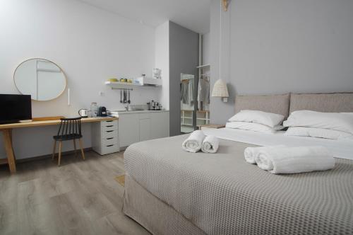 菲尼卡斯Syros Wellness Luxury Suites的白色卧室,配有带毛巾的床