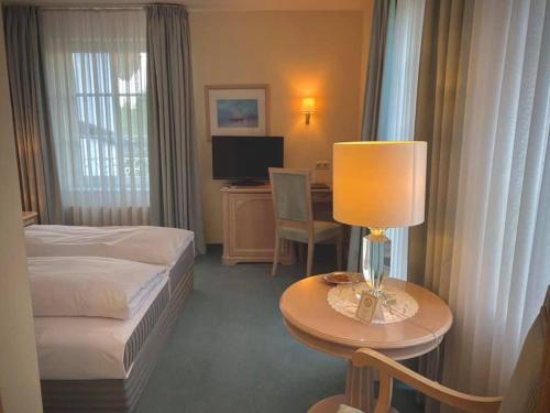 哈尔伯格摩斯丹尼尔斯酒店的酒店客房配有一张床和一张带台灯的桌子
