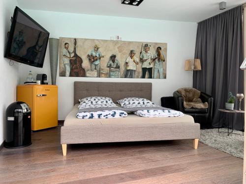 帕绍Guesthouse Passau的卧室配有一张床,墙上挂有绘画作品