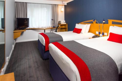 达宁顿堡快捷假日东米德兰机场酒店的酒店客房设有两张床和电视。