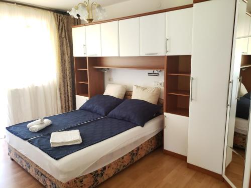 里斯卡Risika Apartmani的一间卧室配有一张带蓝色床单和白色橱柜的床。