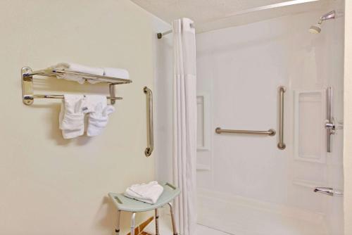 夏洛特夏洛特/伍德劳恩戴斯酒店的带淋浴和凳子的白色浴室