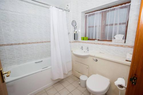 特伦特河畔斯托克Tollgate Hotel & Leisure的浴室配有卫生间、浴缸和水槽。