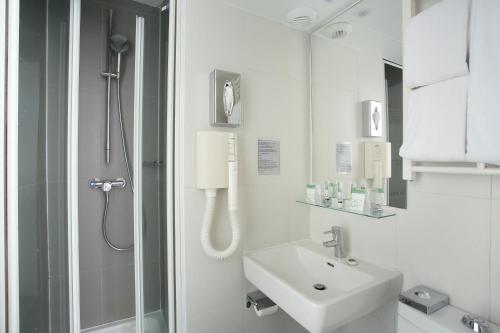巴黎艾菲尔国会大厦酒店的带淋浴和盥洗盆的白色浴室